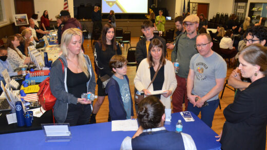 Greenfield residents and City Councilor Barb Warwick speak with DOMI representatives